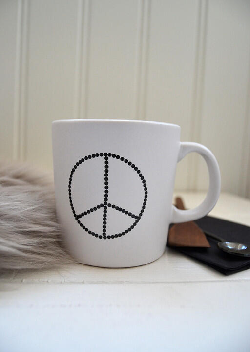 Vit mugg med svart peace symbol. Elina Dahl Design.
